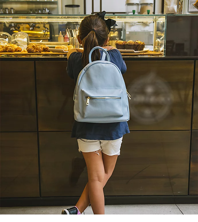 A kid standing in front of a display counter with the coffee shop's logo blurred out