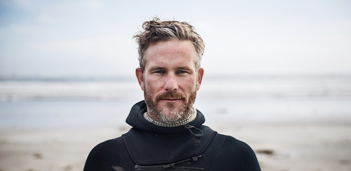 Shallow depth of field headshot of a man standing on a beach