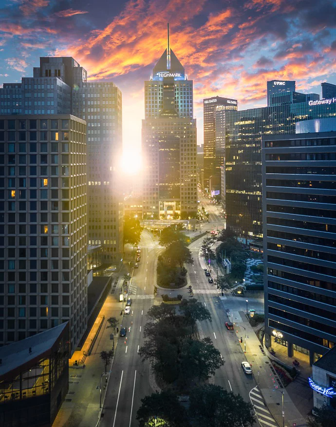 HDR photo of the sun peeking through city buildings