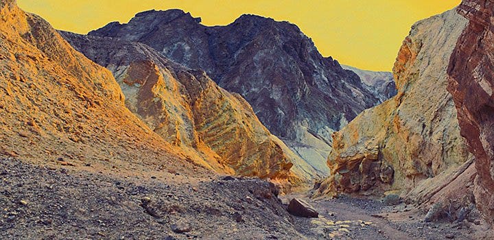 Fine art photograph of a rocky valley colorized in yellow and blue