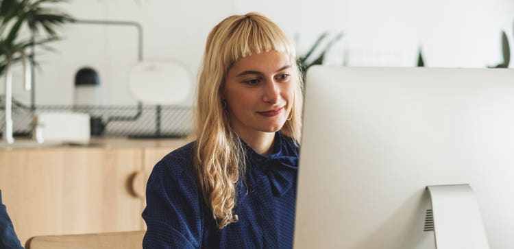 A person slightly smiling while using a desktop computer