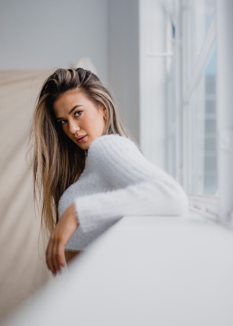 Portrait photography: model posing next to a window