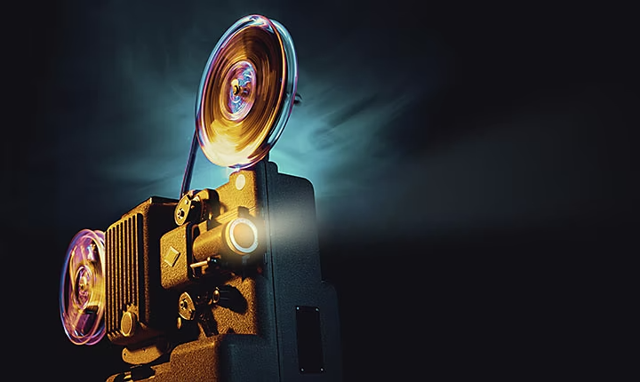 Image of an old film reel projector in a dark room.