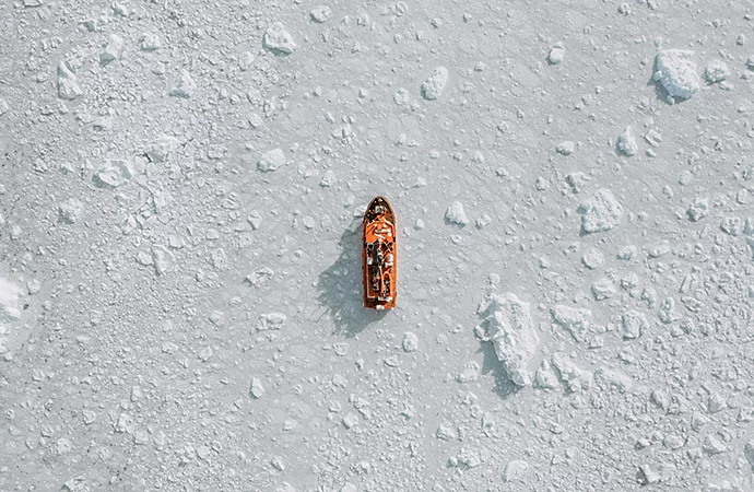 Minimalist fotoğrafçılığa örnek olarak beyaz donmuş suyun ortasında bir geminin kuş bakışı fotoğrafı