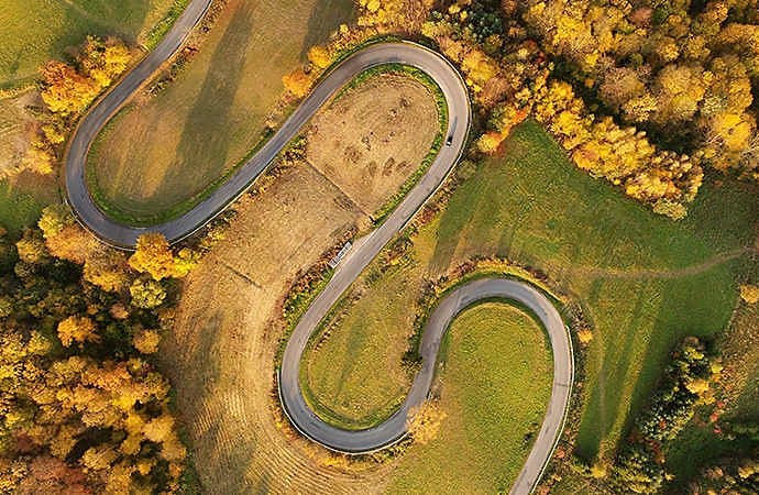 Aerial image of a windy country road in early autumn