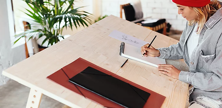 A person drawing flat logo designs at a desk