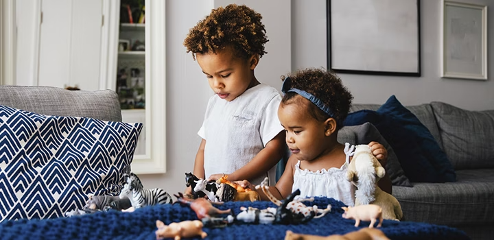 Two kids distracted by toys in order to pose for a family photo