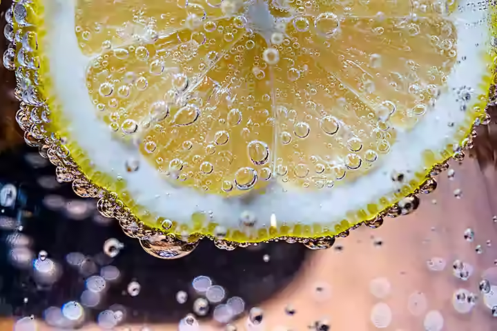 close-up image of a lemon in a fizzy drink