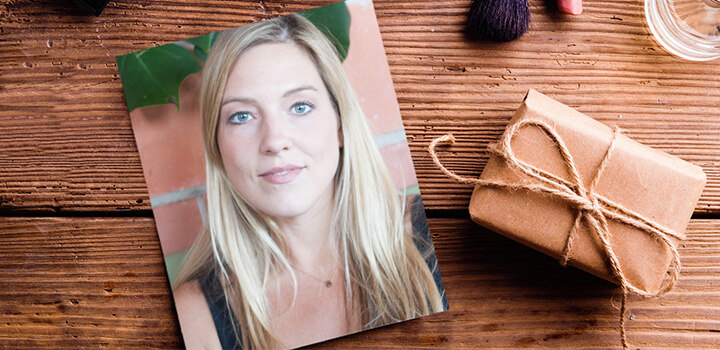 Portrait headshot image of a woman next to brown paper package tied up with string.