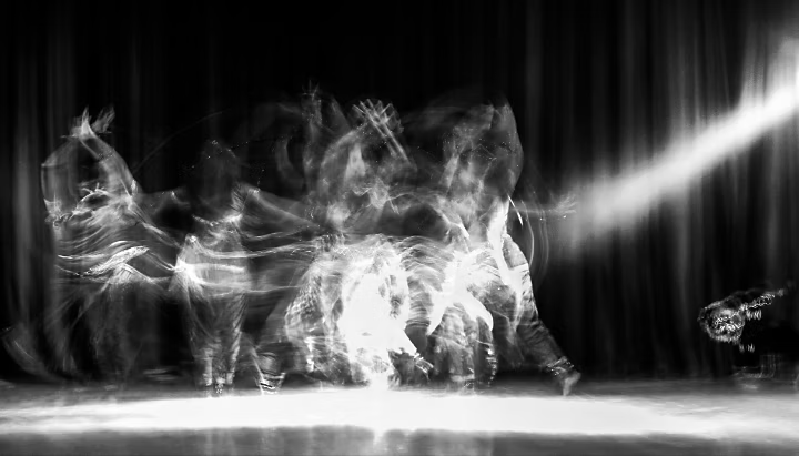 An artistic dancer in a theater shot with a slow shutter speed in order to achieve the desired motion blur