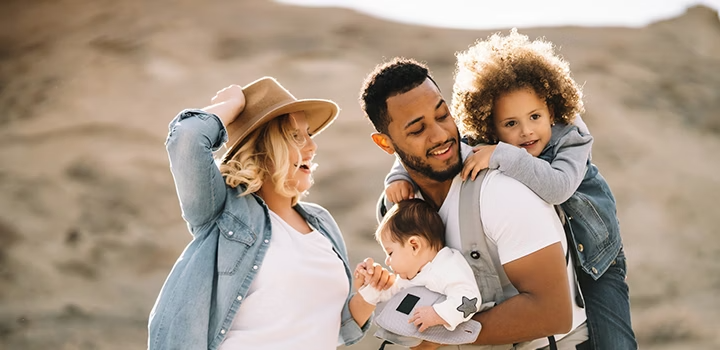 A family of four posing outside for a family photo