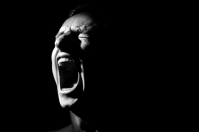 black-and-white-photo-on-a-black-background-distorted-face-screaming