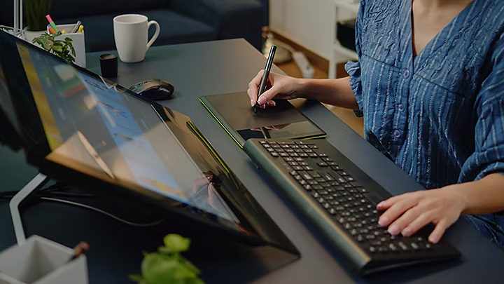 a person at a desktop image editor using a keyboard and stylus