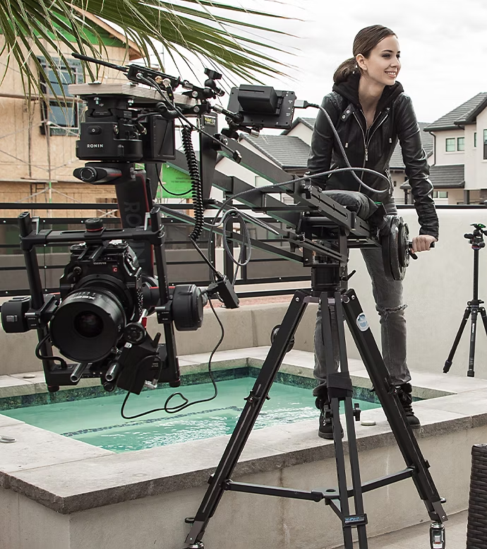 A videographer using a camera crane outside