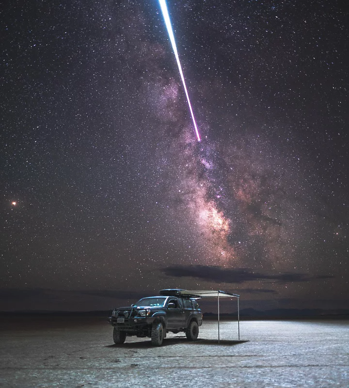 The Milky Way behind a truck parked in a desert