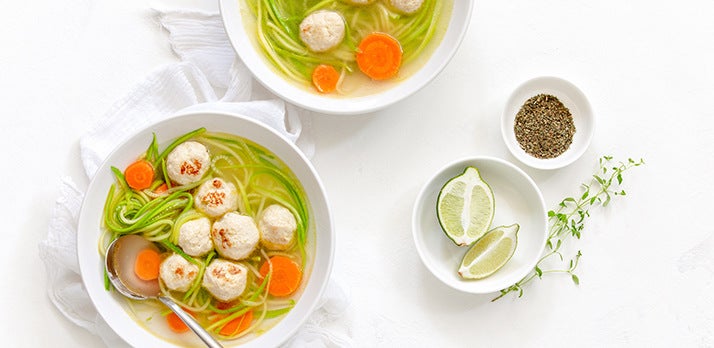 Artfully staged food picture of dumpling soup with limes and seasoning